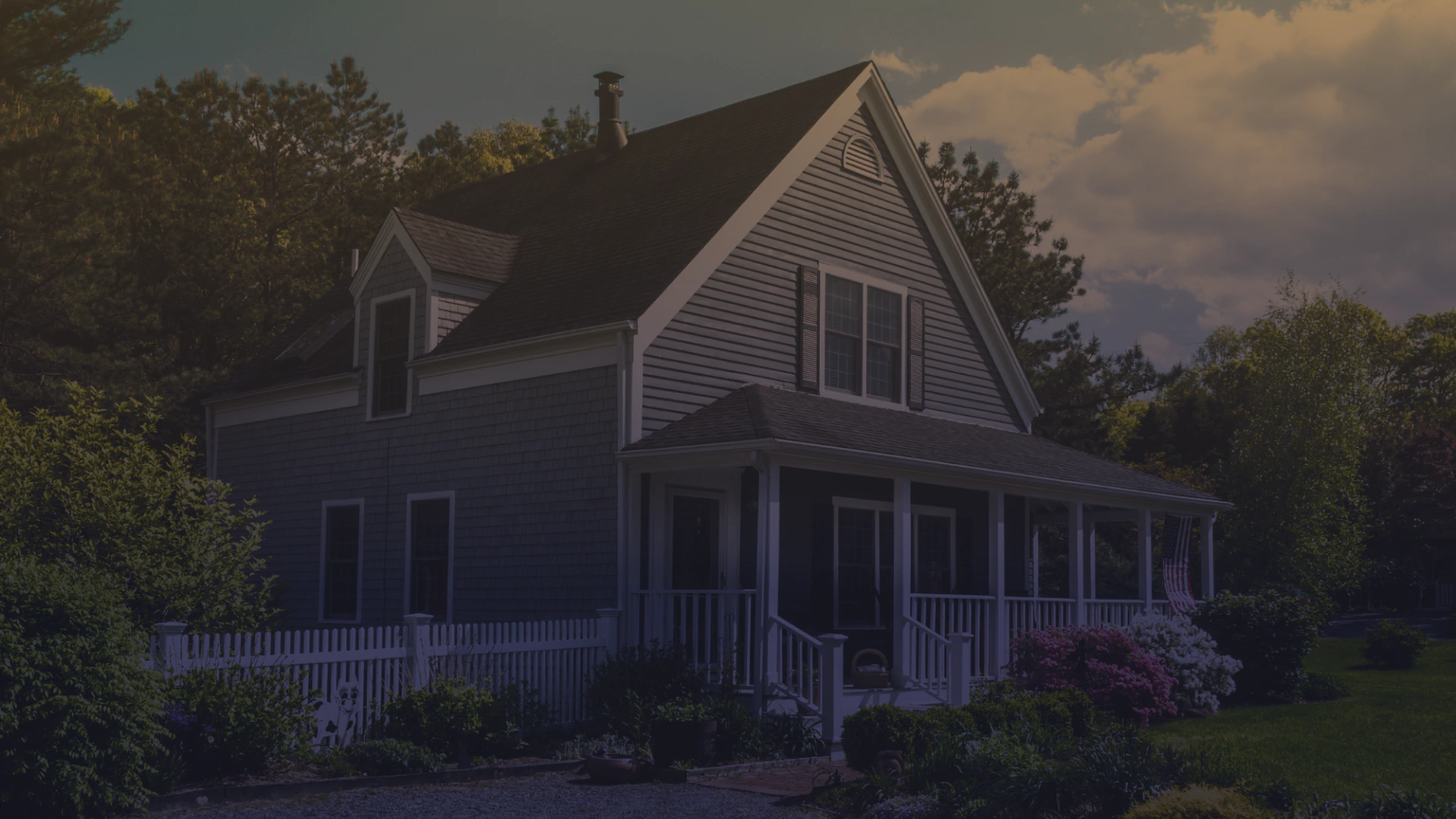 cape house with farmers porch and small white fence